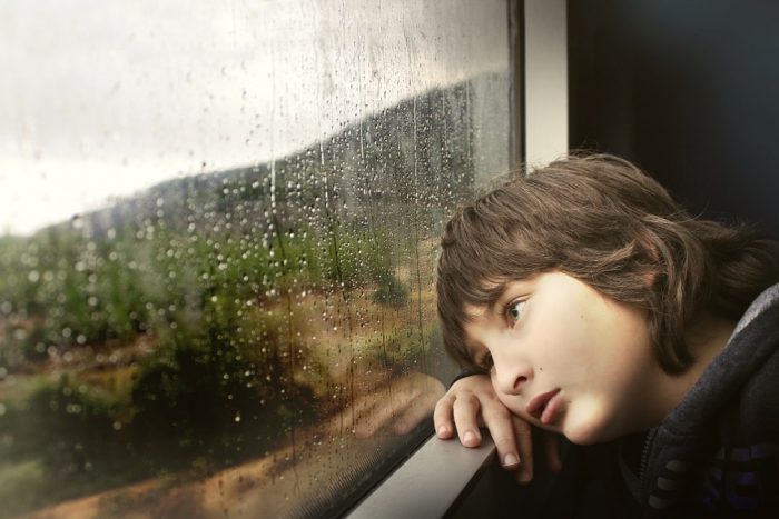 憂鬱な表情で景色を眺める少年